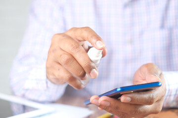 cleaning mobile phone display with sanitizer liquid 