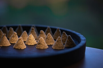 The conical moxa used for treatment is placed in a wooden dish. Moxa close-up. Moxa creative photography.