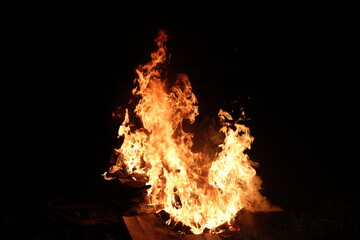 Obraz premium Fire in the night on the wreckage of household items
