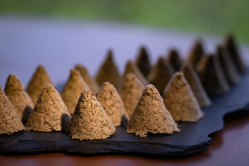 Some hand-made conical moxa used in traditional Chinese medicine is placed on a stone slab. Moxa close-up. Moxa creative photography.