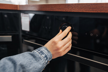 Close up of a woman checking new microwave oven in hypermarket