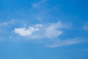 White fluffy clouds against a blue sky. Indigo skies. Translucent haze against the sky.
