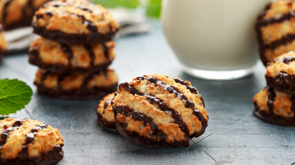 Coconut macaroons cookies with drizzle of chocolate served with glass of milk. Gluten free