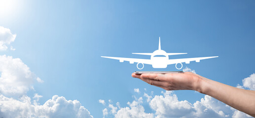 Male hand holding plane airplane icon on blue background. Banner.nline ticket purchase.Travel icons...