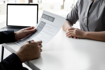 The job interviewer is reviewing job application documents.