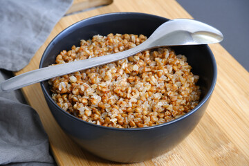 Buckwheat porridge on a black background. Tasty food. Cooking.