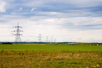 Electricity pylons with lines in the countryside, landscape view, England, Kent, Isle of Grain