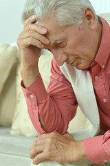 Close up portrait of thoughtful senior man at home