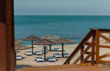Wooden beach umbrellas by the sea in clear weather