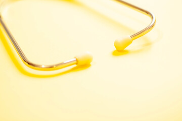 Hospital stethoscope close-up on a yellow background. Medical device for diagnosing diseases