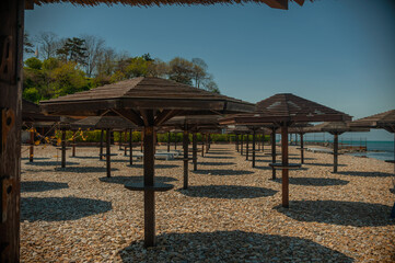 Wooden beach umbrellas by the sea in clear weather