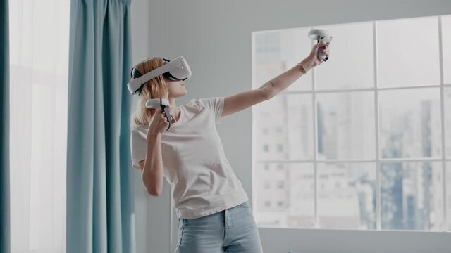 Concentrated woman charges bow playing game with VR headset