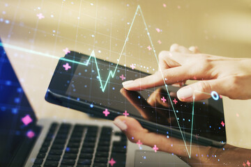 Double exposure of creative abstract heart rate hologram and finger clicks on a digital tablet on...