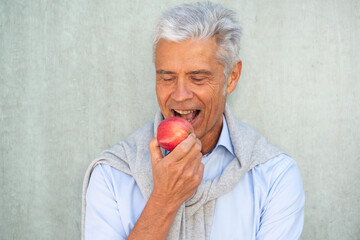 healthy older man eating apple