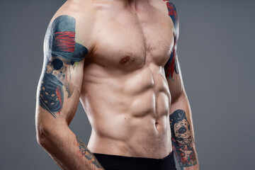 Naklejka premium sporty man with pumped up abs cropped view of tattoo on arms close-up