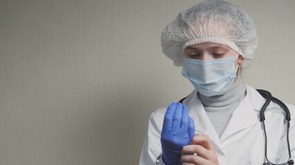 Women doctors greet each other with their elbows, the doctor puts on protective blue gloves on his...