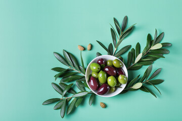 Fresh olives and olive tree branch on a table