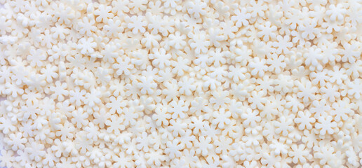 Background of white sweet sugar flowers, pastry topping close up