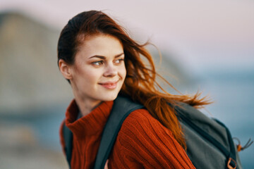 Traveler with a backpack in the mountains and the ocean in the background nature backpack side view