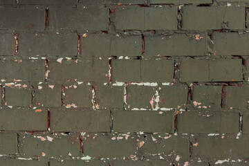 Texture of aged peeling brick wall painted green