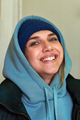Facial portrait of a young beautiful girl in a sweatshirt with a hood