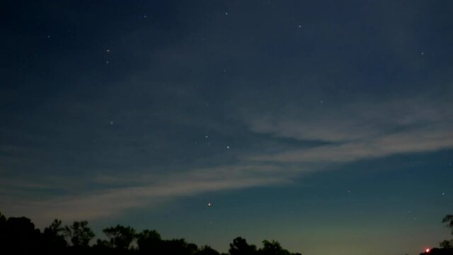 Clouds moving on starry sky at dusk, time lapse