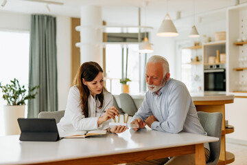 Doctor consulting a patient about prescription medicine on a home visit.