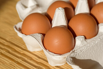 Chicken eggs in a paper carton, straw mat background