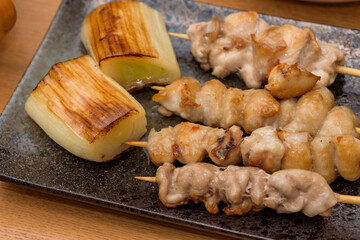 skewered chicken and green onions on a plate, Yakitori