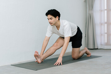 Asian young man doing yoga at home