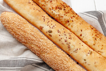 Fresh baguette bread on white wooden table