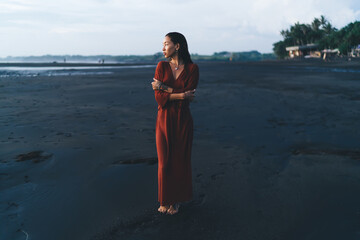 Slim female standing on seashore in cold fog