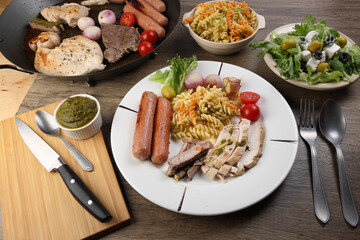 Mix meet chicken beef steak sausage tomato onion garlic fry grill metal pan colorful pasta green salad cheese olive mint basil pesto sauce board knife fork spoon sliced served plate wooden table