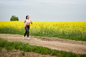 Plus size woman running on a countryside dirt road