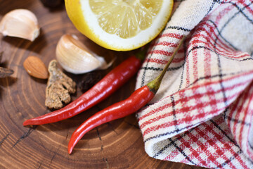 Hot chili peppers, lemon, garlic and spices on a wooden board