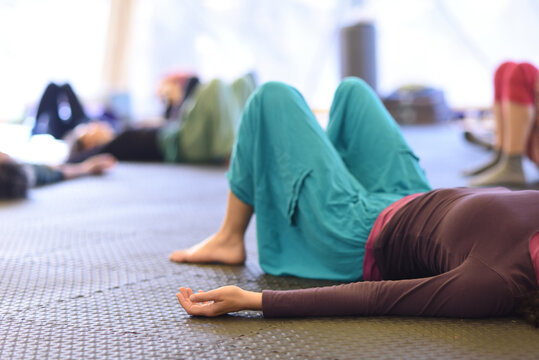 People lying down in a group yoga practice, resting.