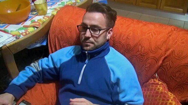 Caucasian young man sitting on a couch at home. Lifestyle.
