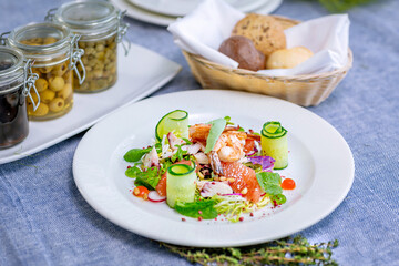 Salad with shrimp, grapefruit, cucumber, radish is served on a large white plate
