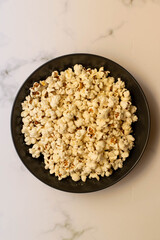 A bowl full of pop corn on a white background