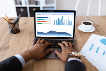 Cropped of black businessman analysing market online on laptop