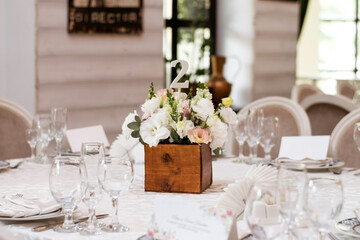 table centerpiece with white and peach rustic floral arrangement in wood box. Rustic wedding table.