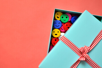 A gift box with smiling circles inside. Give a smile, joy, happiness, positive