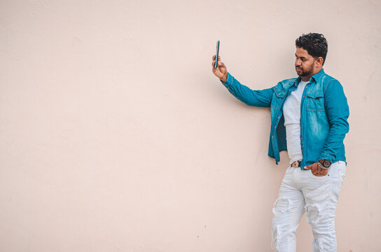 dark bearded latino man talking on smartphone taking a selfie