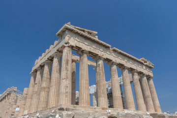 Obraz premium The ancient Parthenon temple on Acropolis hill, famous landmark and tourist attraction in Athens, Greece, in sunny summer day