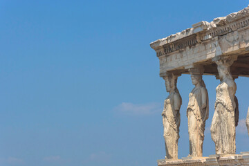 Fototapeta premium Architecture detail of the Caryatids of a ancient temple on Acropolis hill, famous tourist attraction in Athens, Greece, in sunny summer day