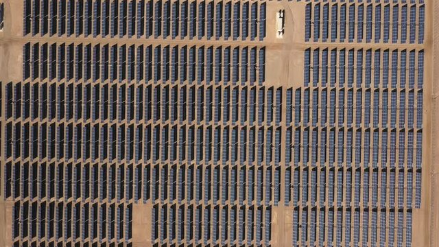 Aerial overhead view footage hundreds solar energy modules or panels rows along the dry arid lands at Atacama Desert, Chile. A photovoltaic solar energy modules symmetrical pattern background video