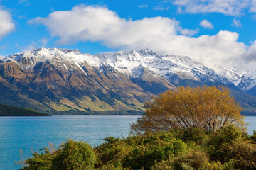 Fototapeta na wymiar Lake Wakatipu in the South Island of New Zealand in autumn, with the snowy mountains of the Southern Alps in the background