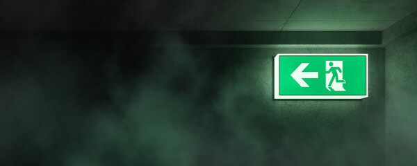 Emergency concept. Illuminated emergency exit sign in hallway or office with smoke rising. Corridor point way out. 3D rendering. - obrazy, fototapety, plakaty
