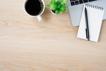 Top view above of Wood office desk table with keyboard of laptop notebook and coffee cup with equipment other office supplies. Business and finance concept. Workplace, Flat lay with blank copy space.