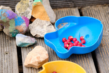 Still life of toys of a child lying outdoors on a wooden ground: sand moulds filled with small...